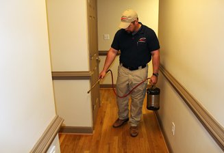 Exterminator Spraying Home for Pest Control