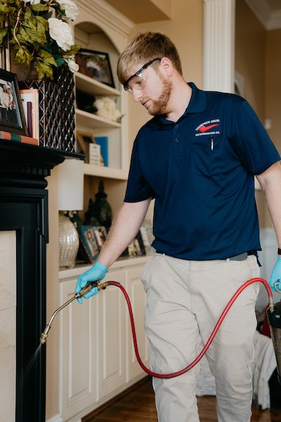 Exterminator in a Home Spraying Pest Control